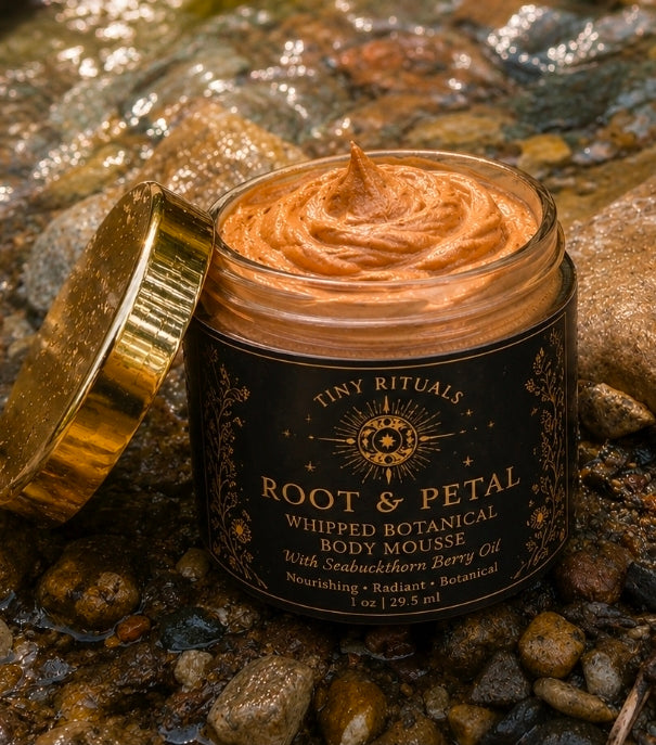 Root & Petal Whipped Botanical Body Mousse open jar showing tinted orange mousse on river rocks